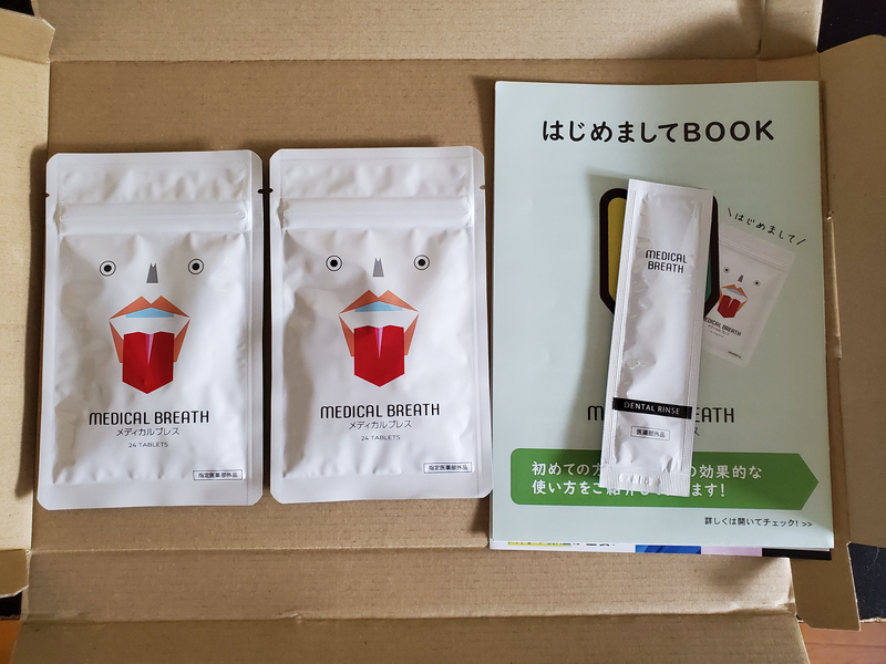 開封したダンボール箱の中に並べられたメディカルブレス2袋とはじめましてBOOKと試供品