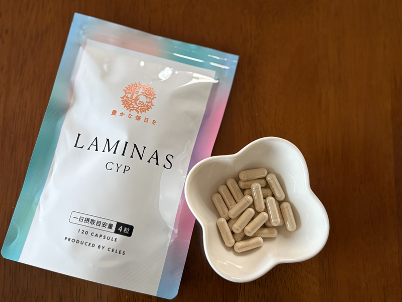 LAMINAS CYP（ラミナスCYP）のパッケージと花形の小皿に入ったベージュ色のカプセル