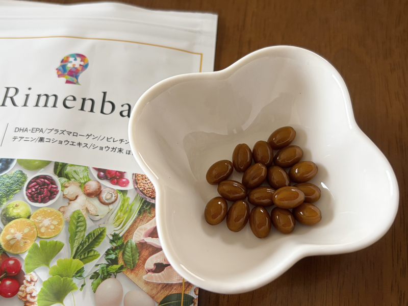 白い小皿に出したリメンバの光沢がある茶色の楕円形カプセル。無臭で小粒な見た目