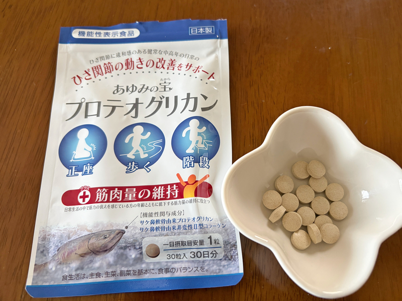 あゆみの宝のアルミパウチパッケージと、白いお皿に並べられた複数のサプリメントの粒