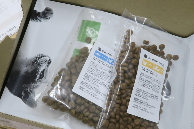 グランツキャットフードの本商品パッケージと、並べて置かれたお試しサンプル小袋2つ
