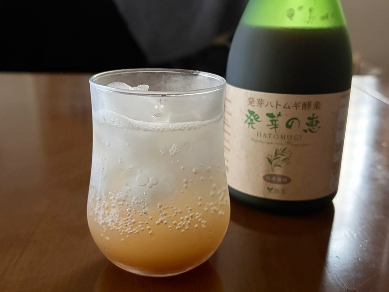 グラスに入った発芽の恵の炭酸割りドリンクとボトルの実物