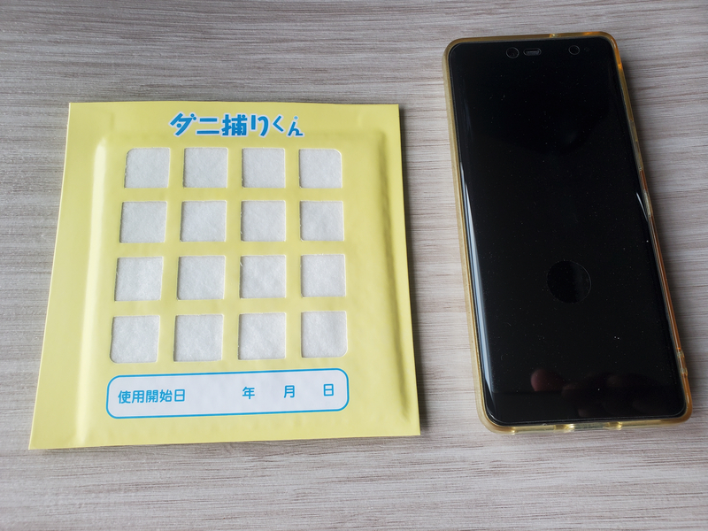 サイズ比較,ダニ捕りくん本体シートとスマートフォンを横に並べたサイズ感の比較